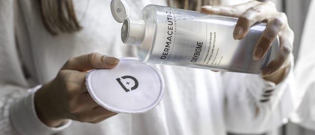 Micellair reinigingswater van Dermaceutic wordt op een herbruikbaar wattenpad gegoten